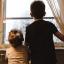 Two young children look out the window. Credit: Kelly Sikkema, Unsplash