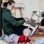 Woman working on a laptop with an infant on the floor next to her. Credit: Standsome Worklifestyle, Unsplash